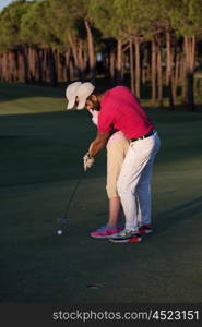 male golf instructor teaching female golf player, personal trainer giving lesson on golf course