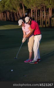 male golf instructor teaching female golf player, personal trainer giving lesson on golf course