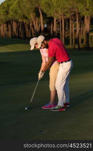 male golf instructor teaching female golf player, personal trainer giving lesson on golf course