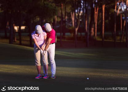 male golf instructor teaching female golf player, personal trainer giving lesson on golf course. golf instructions