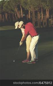 male golf instructor teaching female golf player, personal trainer giving lesson on golf course. golf instructions