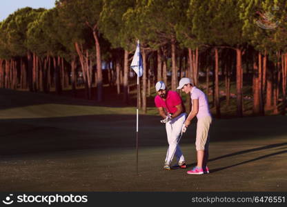 male golf instructor teaching female golf player, personal trainer giving lesson on golf course. golf instructions