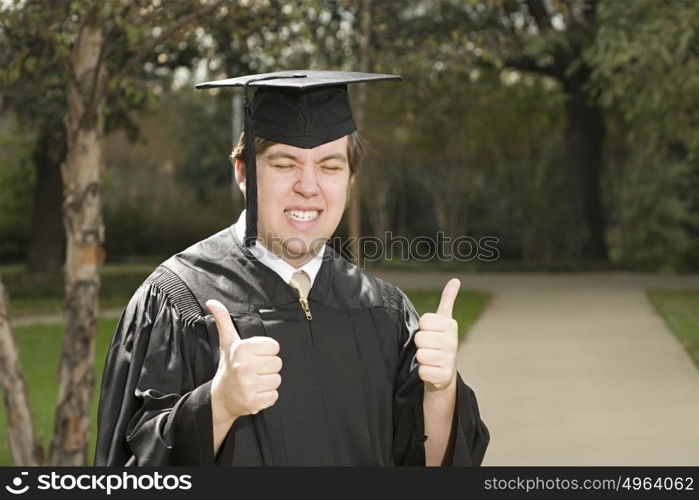 Male graduate giving thumbs up