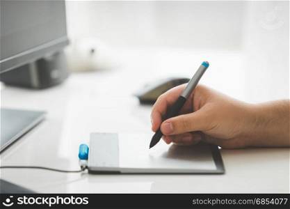 Male graphic designer drawing on digital graphic tablet