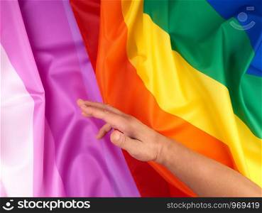 male hand and rainbow flag a symbol of the LGBT community, symbol of freedom of choice of lesbians, gays, bisexuals and transgender people