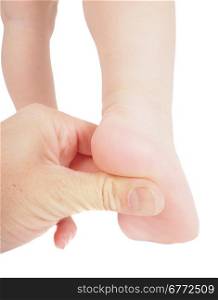 Male hand holding firmly pressing with thumb under foot of toddler in air isolated on white