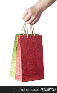 male hand holding two shopping bags isolated on white background