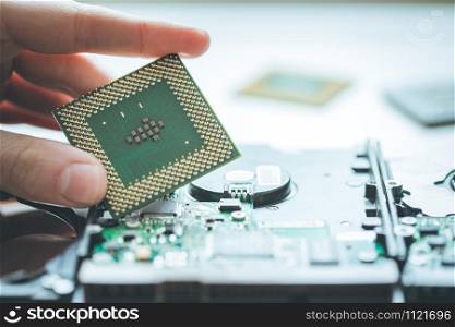 Male hand is holding a cpu, close up; Computer technology.