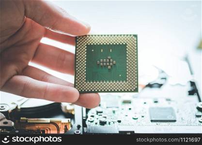 Male hand is holding a cpu, close up; Computer technology.