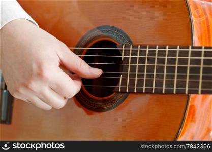 male hand plays on acoustic guitar close up isolated on white background