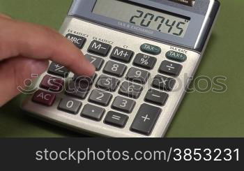 Male hand using a calculator to add bills together