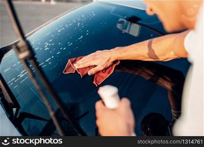Male hand with tool for washing windows, car wash. Carwash station. Male hand with tool for washing windows, car wash