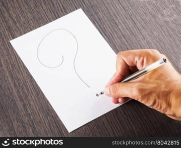 Male hand writing a question mark, horizontal image