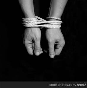Male hands bound with rope