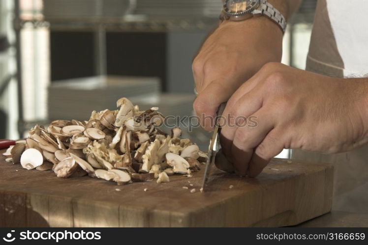 Male hands cutting the mushrooms into slices