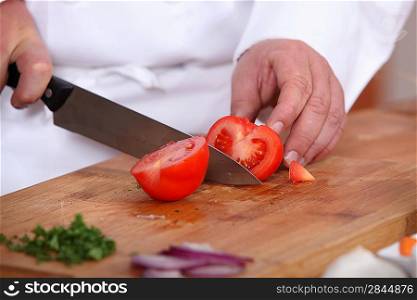 Male hands cutting tomato