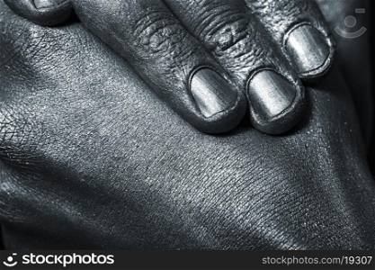 male hands in silver paint on black background