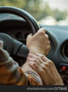 male hands on steering wheel