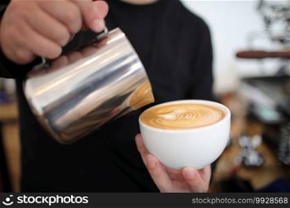 Male hands pouring milk and preparing to making cappuccino coffee