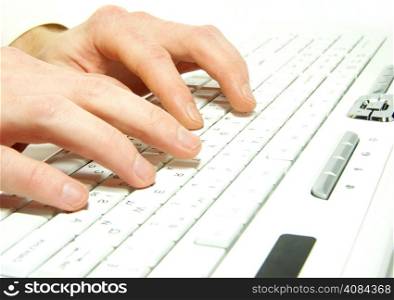 male hands typing on a white computer keyboard