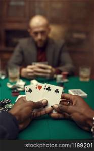 Male hands with cards, poker player in suit on backgroud, casino, risk addiction. Games of chance. Man leisures in gambling house, gaming table with green cloth