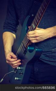 Male hands with electric guitar. Close up, part body adult person is holding instrument and playing. Hobby, music concept. Male hands playing electric guitar