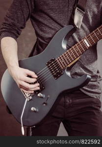 Male hands with electric guitar. Close up, part body adult person is holding instrument and playing. Hobby, music concept. Male hands playing electric guitar