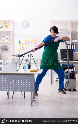 Male handsome professional cleaner working in the office 