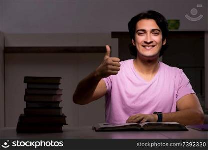 Male handsome student preparing for exams late at home 