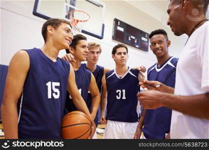 Male High School Basketball Team Having Team Talk With Coach