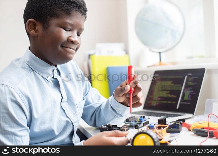 Male High School Pupil Building Robot Car In Science Lesson