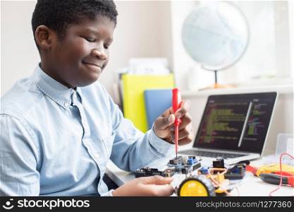 Male High School Pupil Building Robot Car In Science Lesson