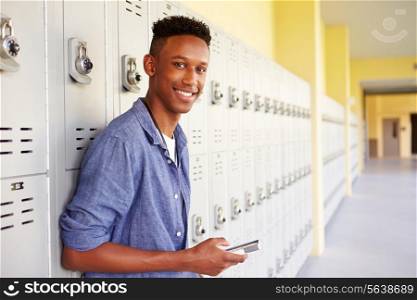 Male High School Student By Lockers Using Mobile Phone