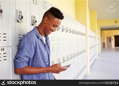 Male High School Student By Lockers Using Mobile Phone
