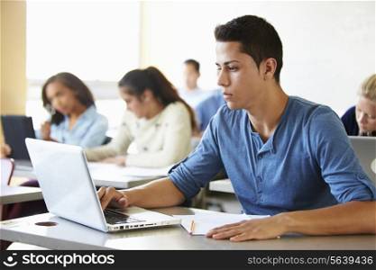 Male High School Student Using Laptop In Class