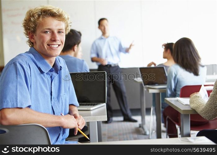 Male High School Student Using Laptop In Classroom