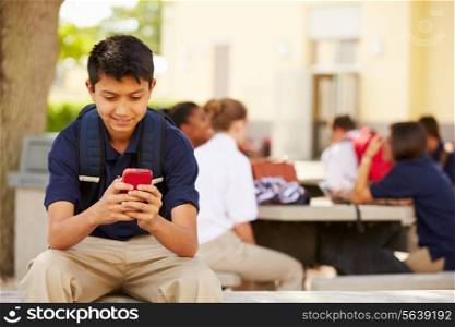 Male High School Student Using Phone On School Campus