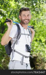 male hiker looking to the side walking in forest