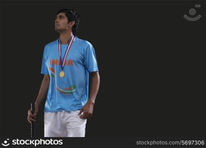 Male hockey player looking up with pride against black background