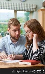 Male Home Tutor Helping Girl Struggling With Studies