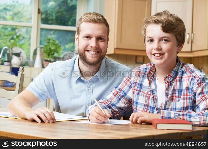 Male Home Tutor Helping Teenage Boy With Studies