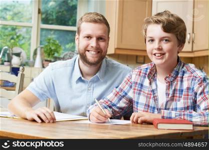 Male Home Tutor Helping Teenage Boy With Studies