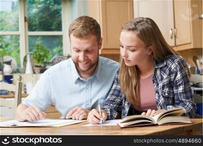 Male Home Tutor Helping Teenage Girl With Studies