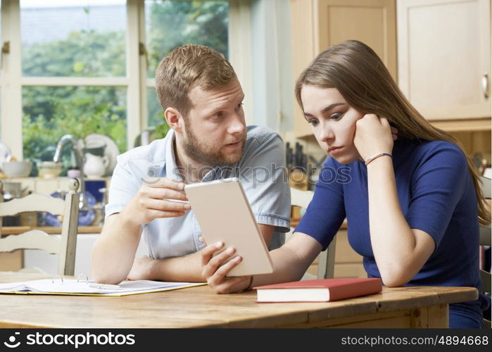 Male Home Tutor Helping Teenage Girl With Studies