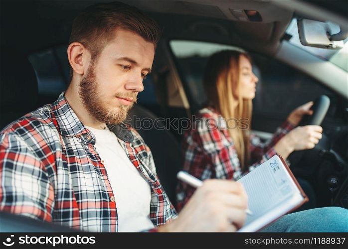 Male instructor and female student in vehicle, driving lesson, car school concept. Test for beginner. Male instructor and female student, driving lesson