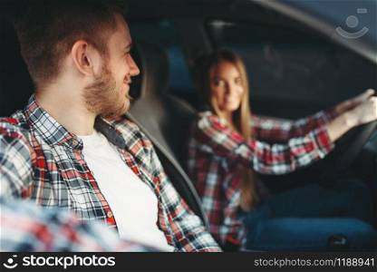 Male instructor and female student smiling in vehicle, driving lesson, car school concept. Test for beginner. Instructor and female student smiling in vehicle