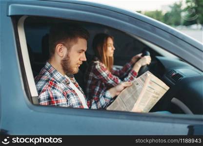 Male instructor taking the exam, female student drives vehicle, driving lesson, car school concept. Test for beginner. Instructor taking the exam, female student drives