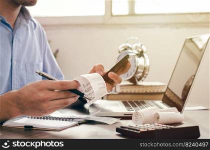 Male investor using phone and calculating bills in home office Check about expenses in investment, business, taxes, pay employees.