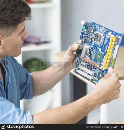 male it technician looking pc motherboard