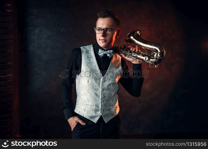 Male jazz man posing with saxophone. Jazz-man with sax concept. Saxophonist with classical brass band instrument